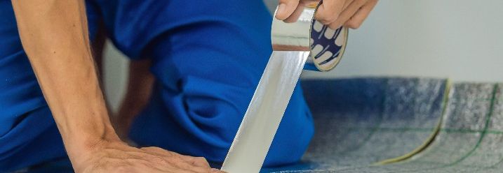 Handwerker verklebt Dämmung mit Aluminiumband